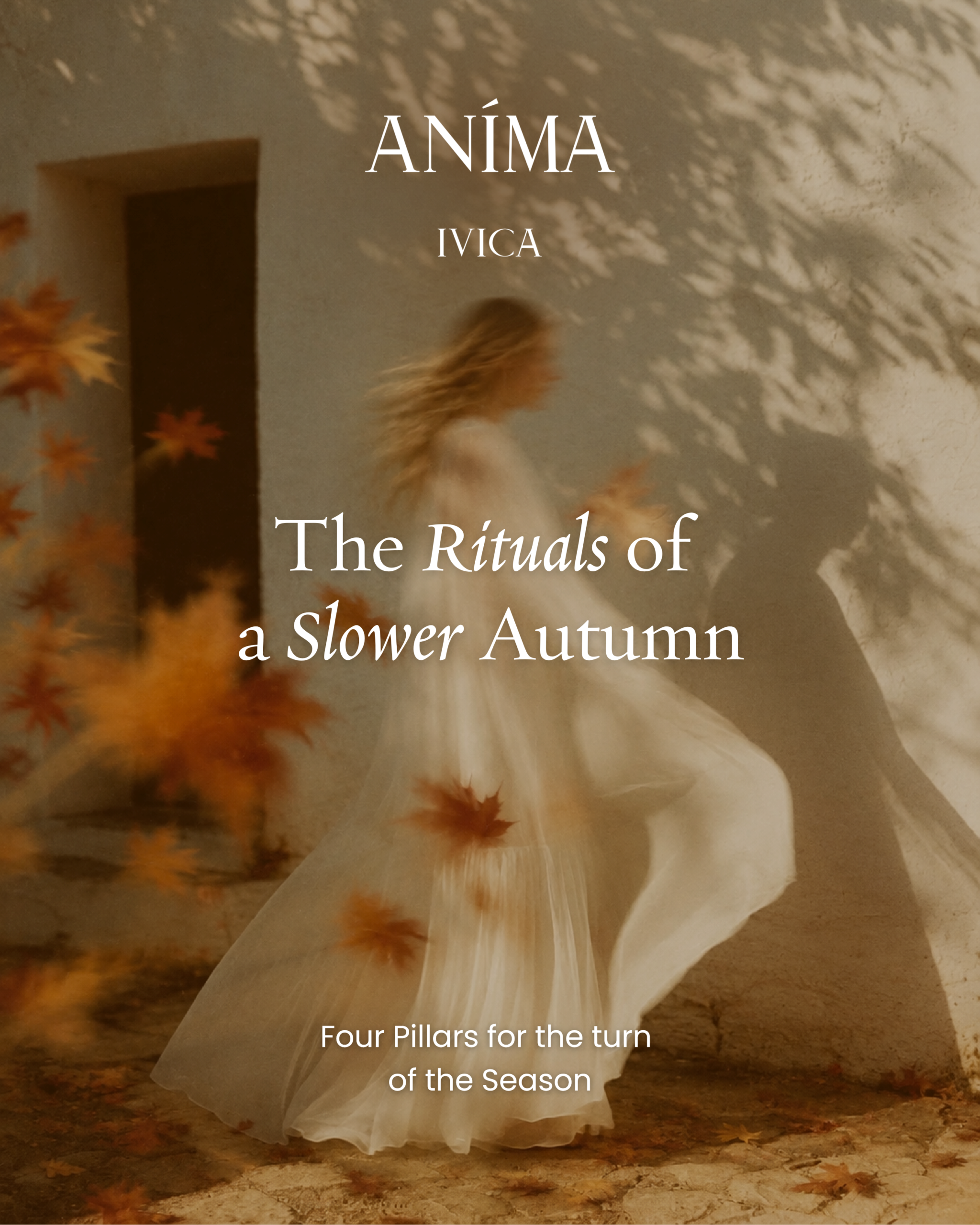A woman in flowing white fabric walks past a sunlit stone wall scattered with autumn leaves